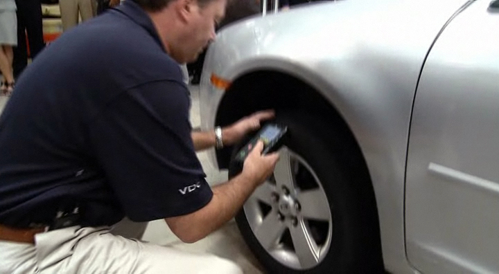 Technician using scan tool to relearn sensor to vehicle.